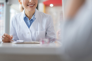 Nice smiling doctor talking to her little patient