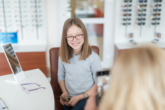 Cheerful smart little girl visiting her optician