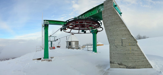 Ski lift chair engine by misty snowy day in mountains area. Pylypets, Ukraine