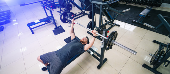 Muscular man training with barbell in gym. Beautiful body. Fitness concept.