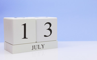 July 13st. Day 13 of month, daily calendar on white table with reflection, with light blue background. Summer time, empty space for text