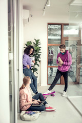 Student sitting on the floor with laptop talking to friends