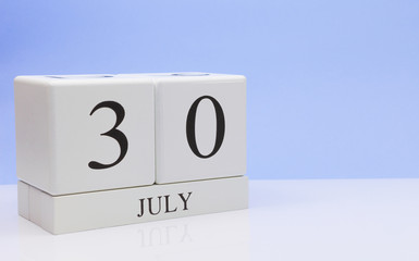 July 30st. Day 30 of month, daily calendar on white table with reflection, with light blue background. Summer time, empty space for text