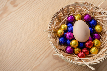 Fototapeta na wymiar colorful easter eggs in a basket on wooden background.