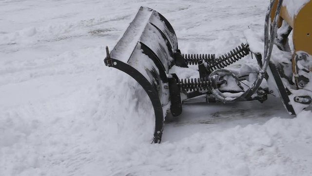 Slow motion snow plow at work. Clearing driveway and making a snowpile. Snow falling. Winter in Canada.