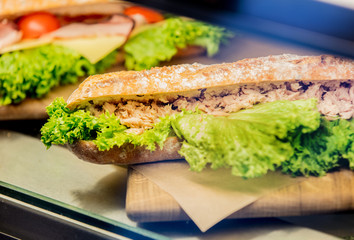 Side view at sandwich snack with salat under glass