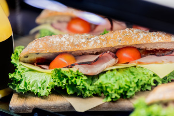 Side view at sandwich snack with salat under glass