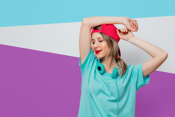 girl in pink cap and blue t-shirt with headphones