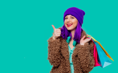 girl with purple hair in jacket holding shopping bags