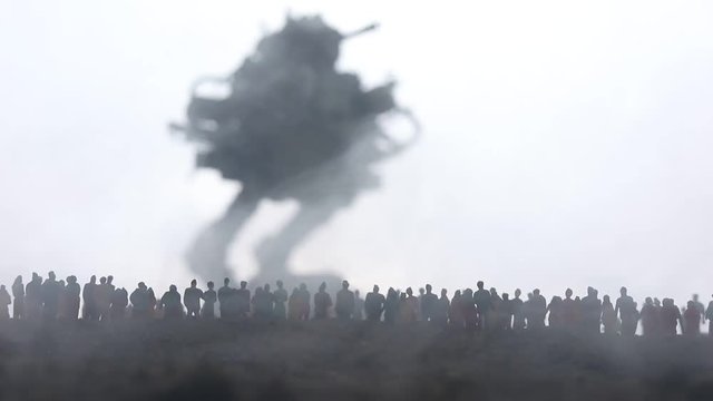 Artwork decoration. Silhouette of giant robot prepare attack crowd at sunset. Horror view of futuristic cyborg going to attack scared people. Selective focus.