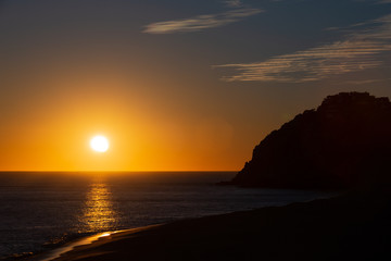 Sunset on the beach by the cliffs in Cabo San Lucas