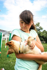 The girl plays, trains the little dog of the Petit Brabancon breed