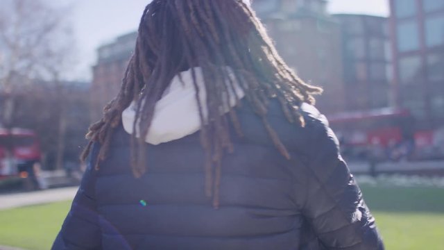 Handsome mixed race man with dreadlocks enjoying music on his headphones, in slow motion