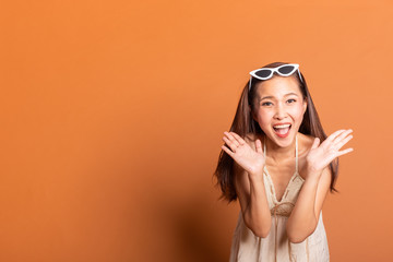 Young Asian woman in summer swimming suit smile happy over orange background with copy space