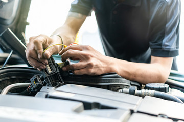 People or mechanic car repair during investigate cause of problem (electric system check) or working on automobile gasoline or diesel engine at garage