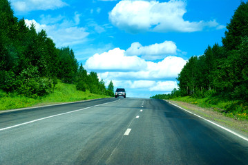 single car on speed way through wild forest, journey or freedom concept