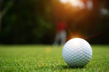 Blurred golf ball on green in beautiful golf course with sunset. Golf ball close up in golf coures...