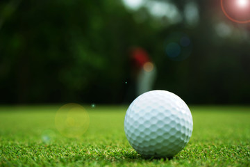 Blurred golf ball on green in beautiful golf course with sunset. Golf ball close up in golf coures at Thailand