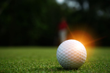 Blurred golf ball on green in beautiful golf course with sunset. Golf ball close up in golf coures at Thailand