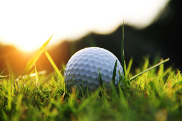 golf ball in beautiful golf course with sunset. Golf ball close up in golf coures at Thailand