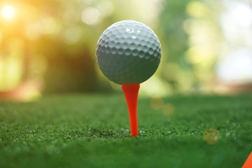 golf ball on tee in beautiful golf course with sunset. Golf ball close up in golf coures at Thailand