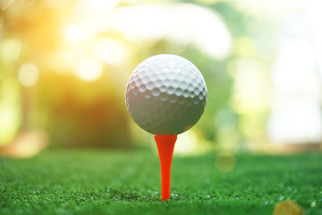 golf ball on tee in beautiful golf course with sunset. Golf ball close up in golf coures at Thailand