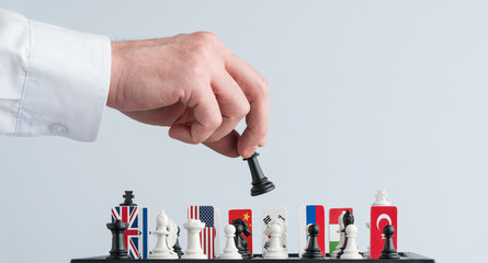 Politician's hand moves a chess piece. Conceptual photo of a political game and strategy.