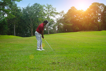 Blurred golfer playing golf in beautiful golf course in the evening golf course with sunshine in thailand