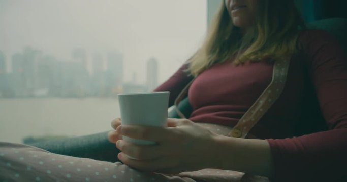 Woman drinking coffee and talking by window