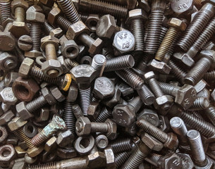 Many small and large bolts, nuts. rusty and dirty. view from above