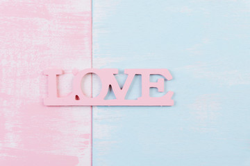Valentines day and love concept. Wooden letters forming word LOVE written on white pink and blue wooden background.