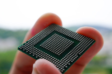 Close up of Semiconductor BGA IC with Man finger hold on it