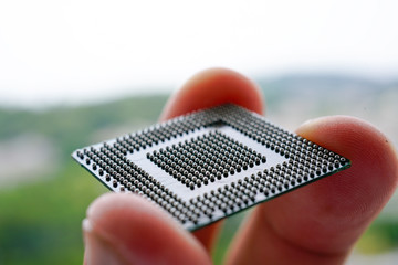 Close up of Semiconductor BGA IC with Man finger hold on it