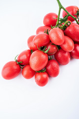 a bunch of red small tomatoes on a white background
