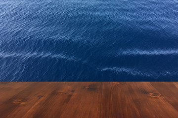 old brown oak wooden deck table on the blue sea background, wood table.