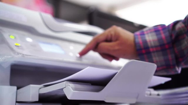 Business office Concept : Hand Businessman is process of press paper on laser print cartridge, lay down or take papers from printer at Busy Offices background