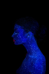 Profile of an alien woman with blue skin and pink lips, ultraviolet makeup on a black background.