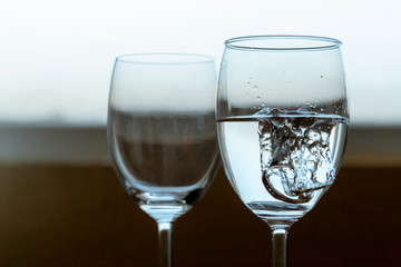 Wedding couple diamond rings falls in glass with water.