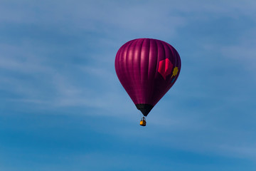Violet hot air balloon on blue sky