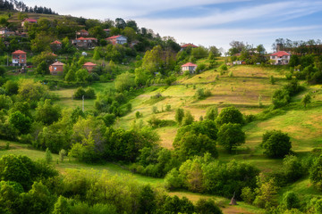 Spring is coming... Amazing spring view with a little village in Rhodopi Mountains, Bulgaria. Magnificent landscape, green fields, small houses
