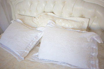 Fototapeta na wymiar White bed with pillows. Tender morning of the bride. Bedroom