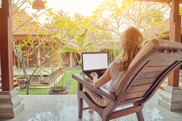 Girl using laptop on a home porch / terrace.