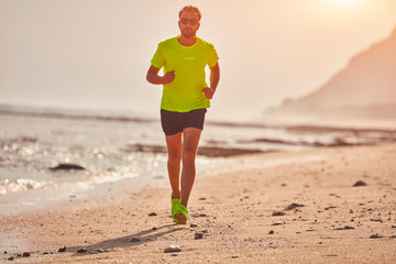 Man running / jogging on a tropical exotic beach.