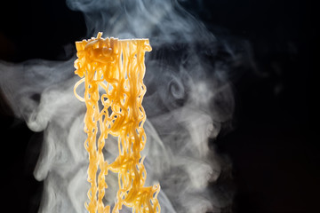 Noodles with steam and smoke in black background, selective focus., Asian meal, junk food concept