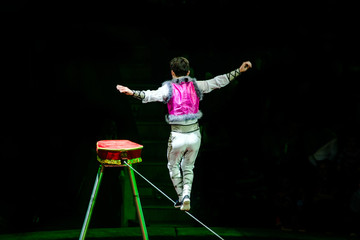 Acrobat walking on a rope during a performance in the circus 
