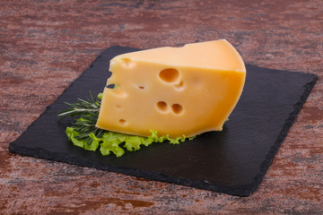 Maasdam cheese  in the board served salad leaves
