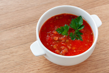 Tomato-lentil soup, decorated with herbs. Ingredients: tomatoes in their own juice, lentils, onions, spices.