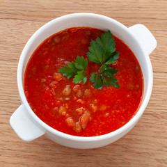 Tomato-lentil soup, decorated with herbs. Ingredients: tomatoes in their own juice, lentils, onions, spices. Square format.