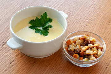 Cheese cream soup with cream, potatoes and spices, decorated with herbs.