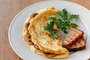Omelet with mushrooms, decorated with herbs and toast.